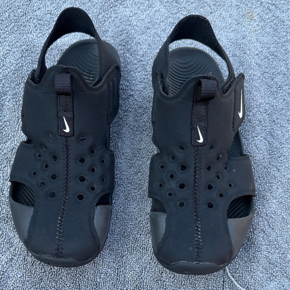 Nike Black Children’s Outdoor Water Sandals with White Swoosh.The size is about